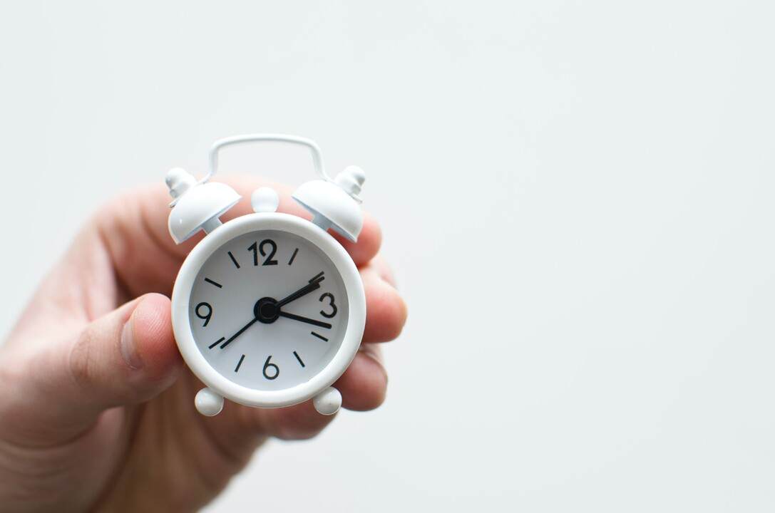 A hand holding a clock